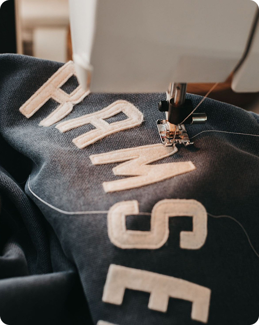 Embroidery machine stitching lettering onto dark fabric